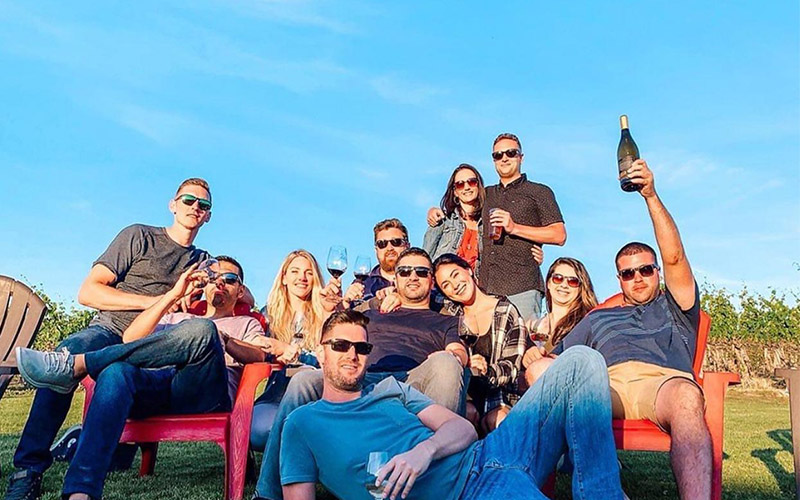 group of young adults enjoying sun and wine