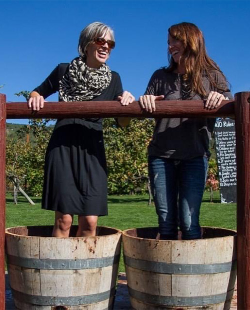 2 women standing in barrels