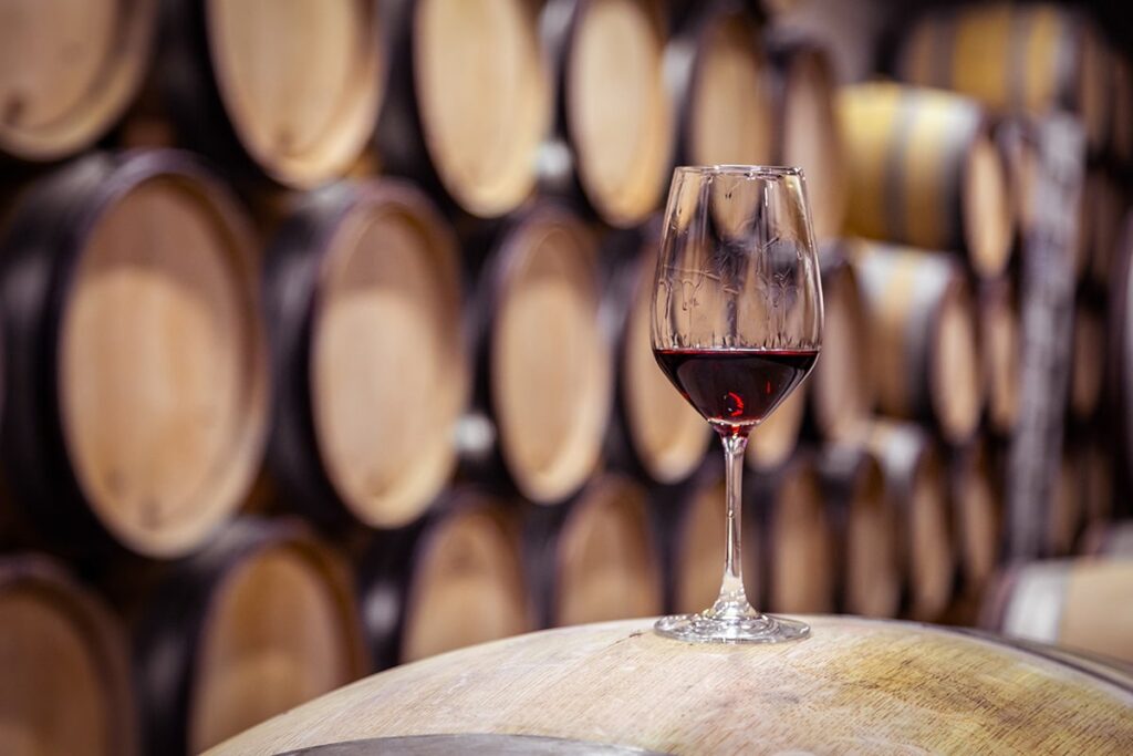 A glass of wine in a barrel room