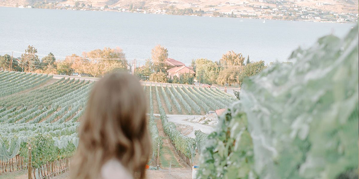 Woman looking at the lake from a vineyard